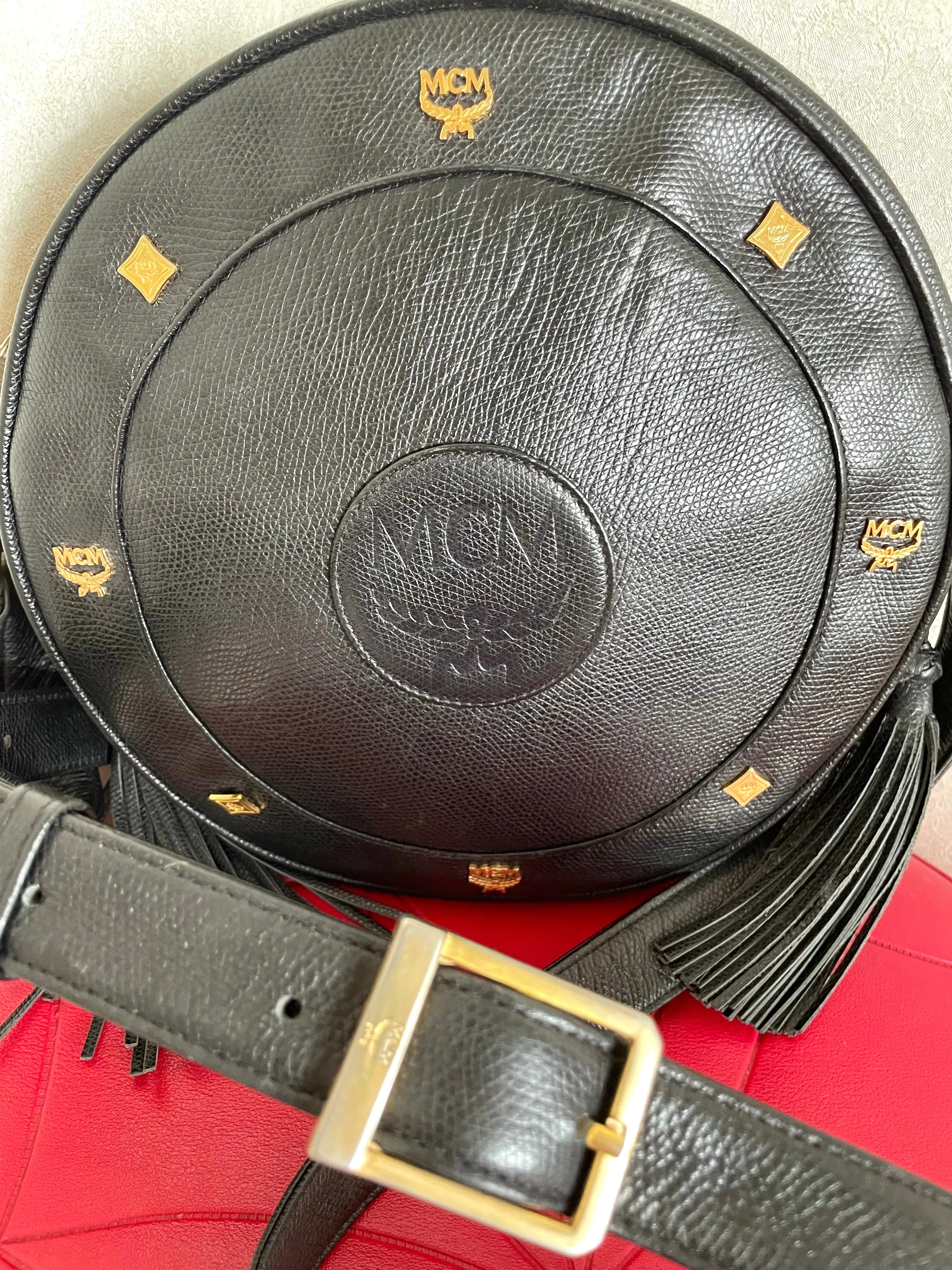 Vintage MCM black suzy wong, grained leather round shoulder bag with golden logo studs and fringes. Designed by Michael Cromer.0407051