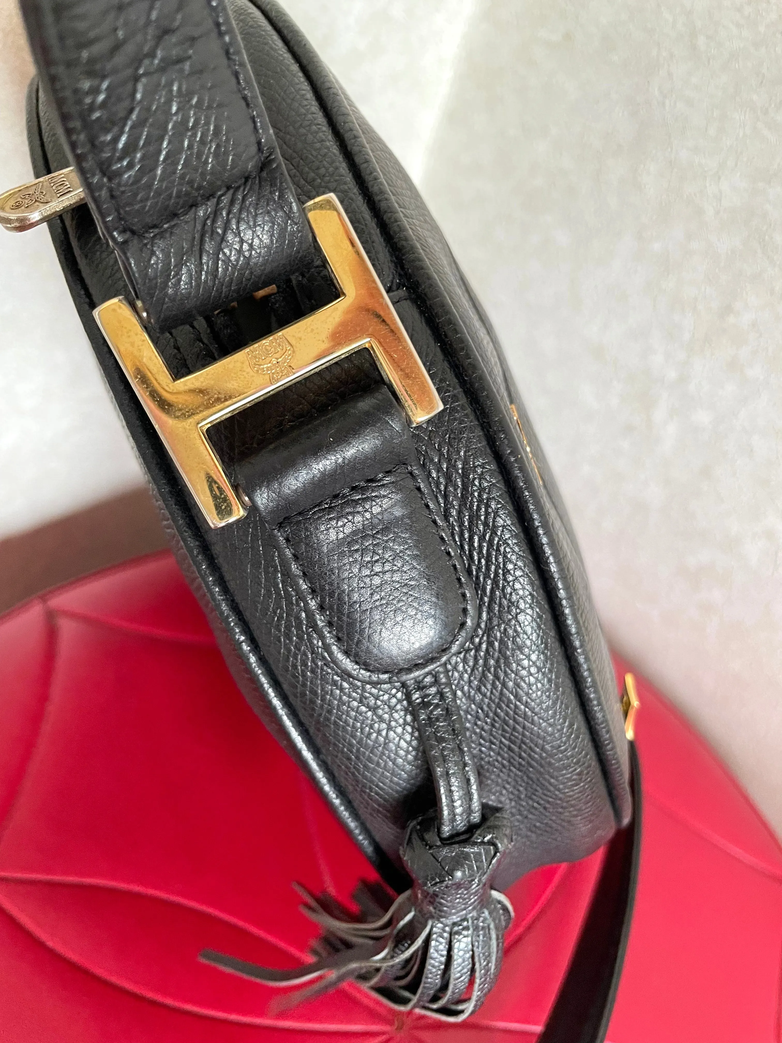 Vintage MCM black suzy wong, grained leather round shoulder bag with golden logo studs and fringes. Designed by Michael Cromer.0407051