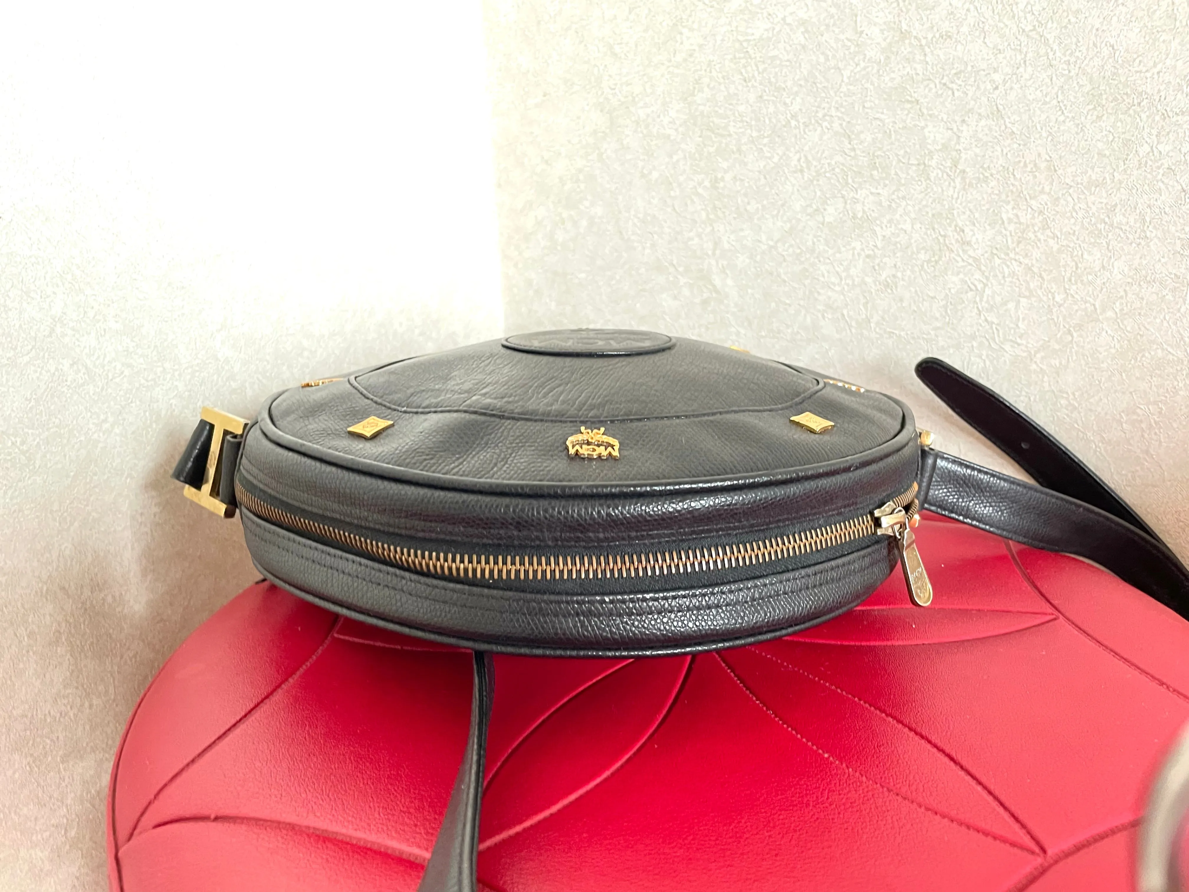 Vintage MCM black suzy wong, grained leather round shoulder bag with golden logo studs and fringes. Designed by Michael Cromer.0407051