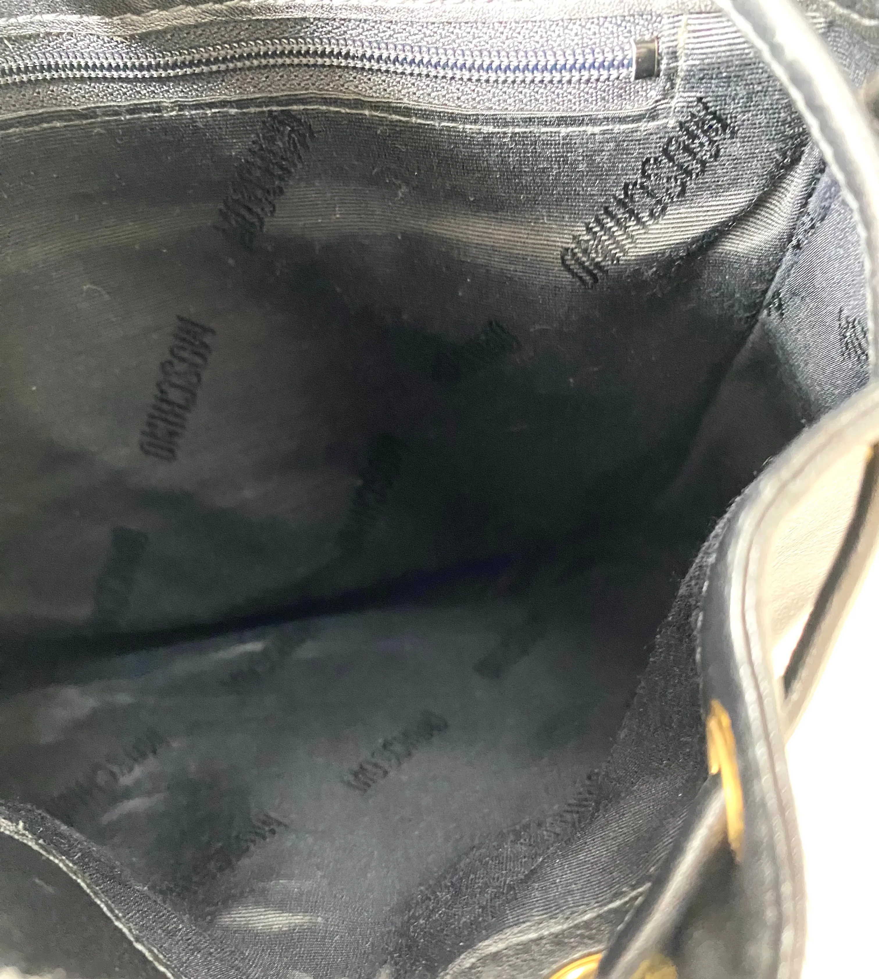 Vintage Moschino black leather shoulder bag with golden cute dangling charms. Heart, safety pin, trumpet, sacks, and guitar. 050725