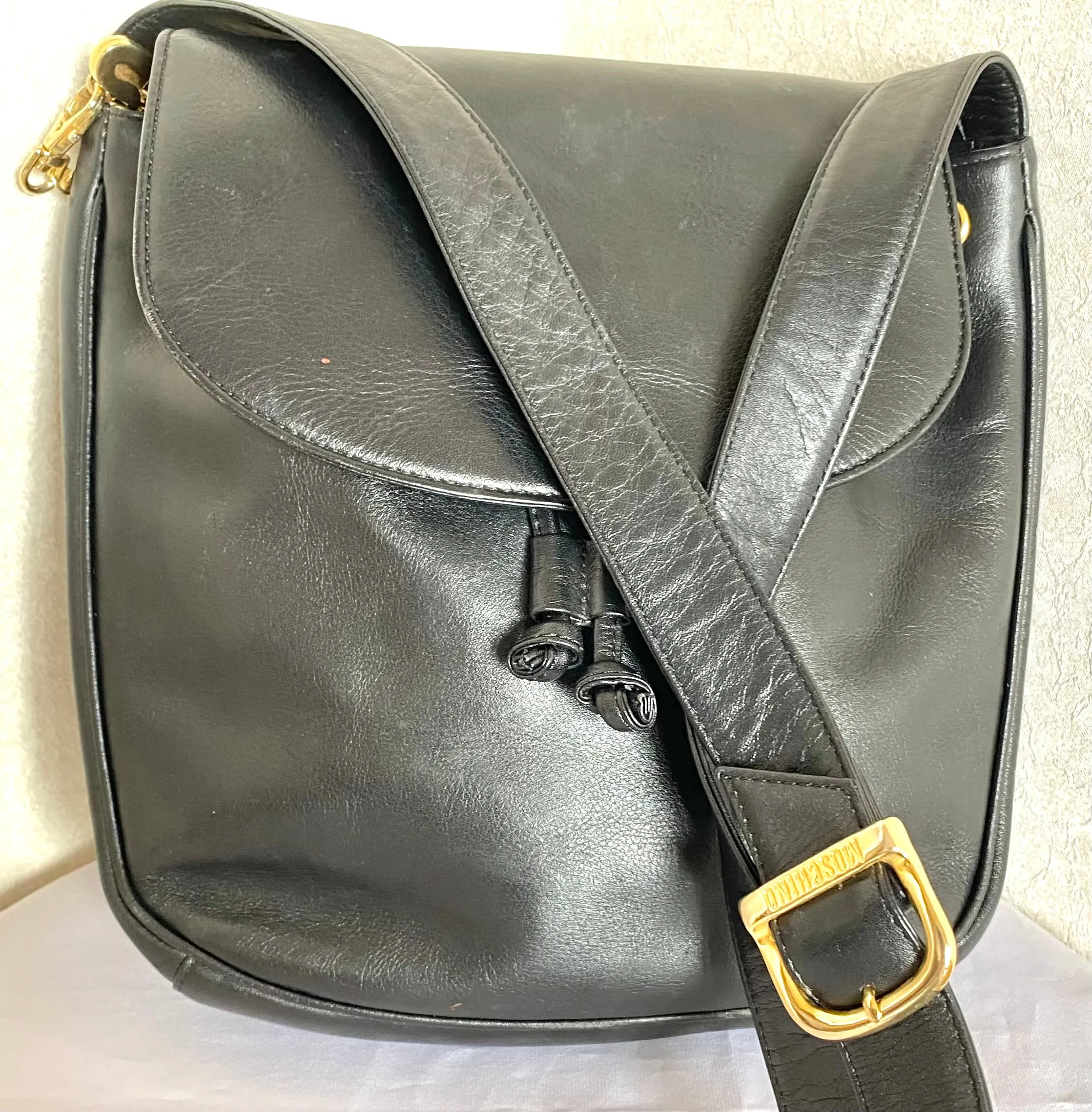 Vintage Moschino black leather shoulder bag with golden cute dangling charms. Heart, safety pin, trumpet, sacks, and guitar. 050725